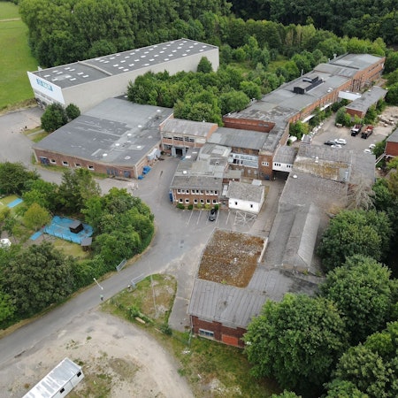 Luftbild eines Industrieunternehmens mit alten und neuen Gebäuden.