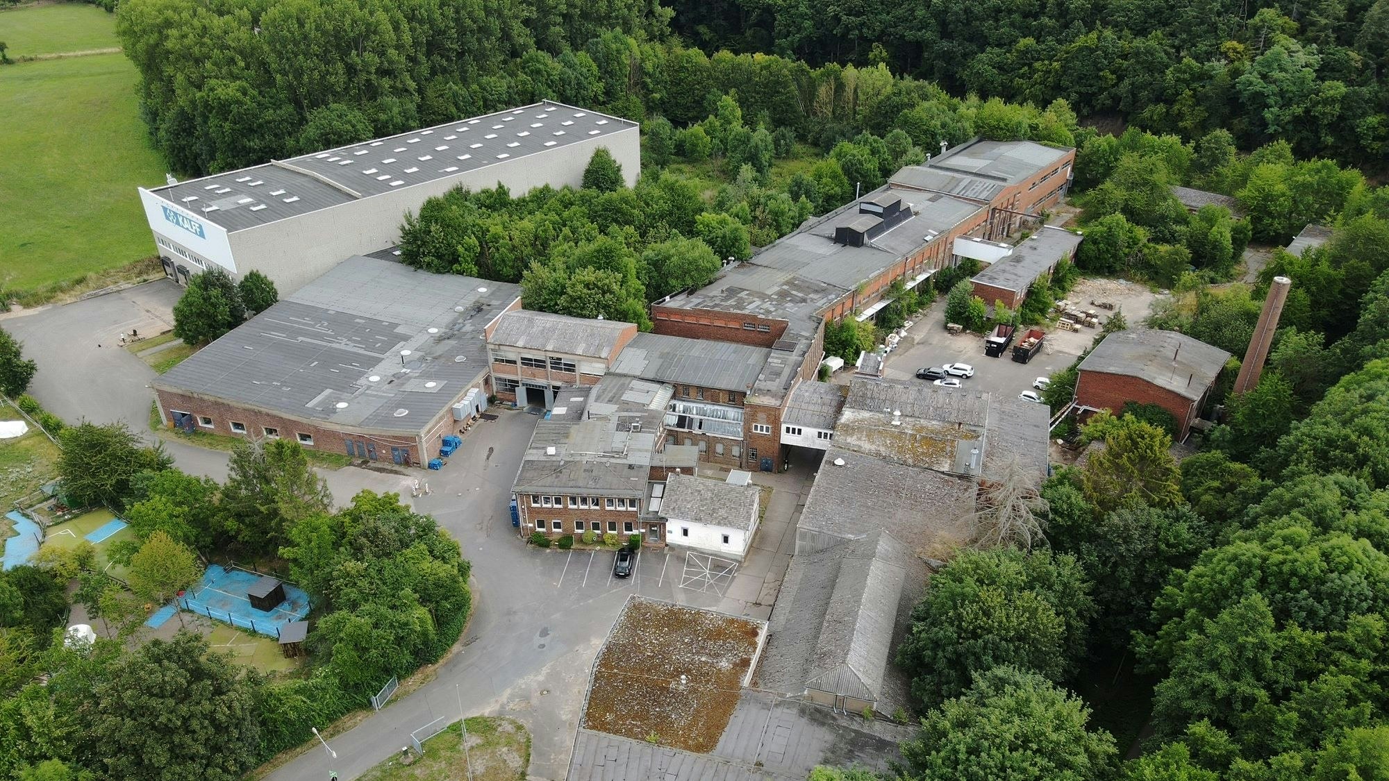 Luftbild eines Industrieunternehmens mit alten und neuen Gebäuden.