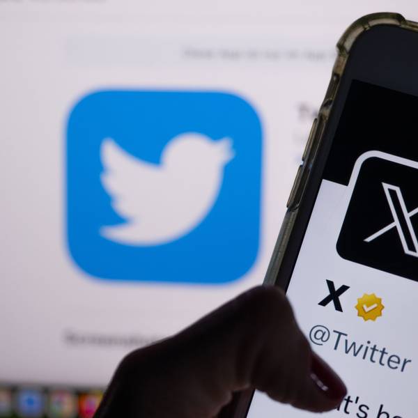 Auf dem offiziellen Profil von Twitter auf dem Bildschirm eines Smartphones ist der weiße Buchstabe X auf schwarzem Hintergrund zu sehen, während im Hintergrund das bisherige Logo des Kurznachrichten-Dienstes Twitter angezeigt wird.