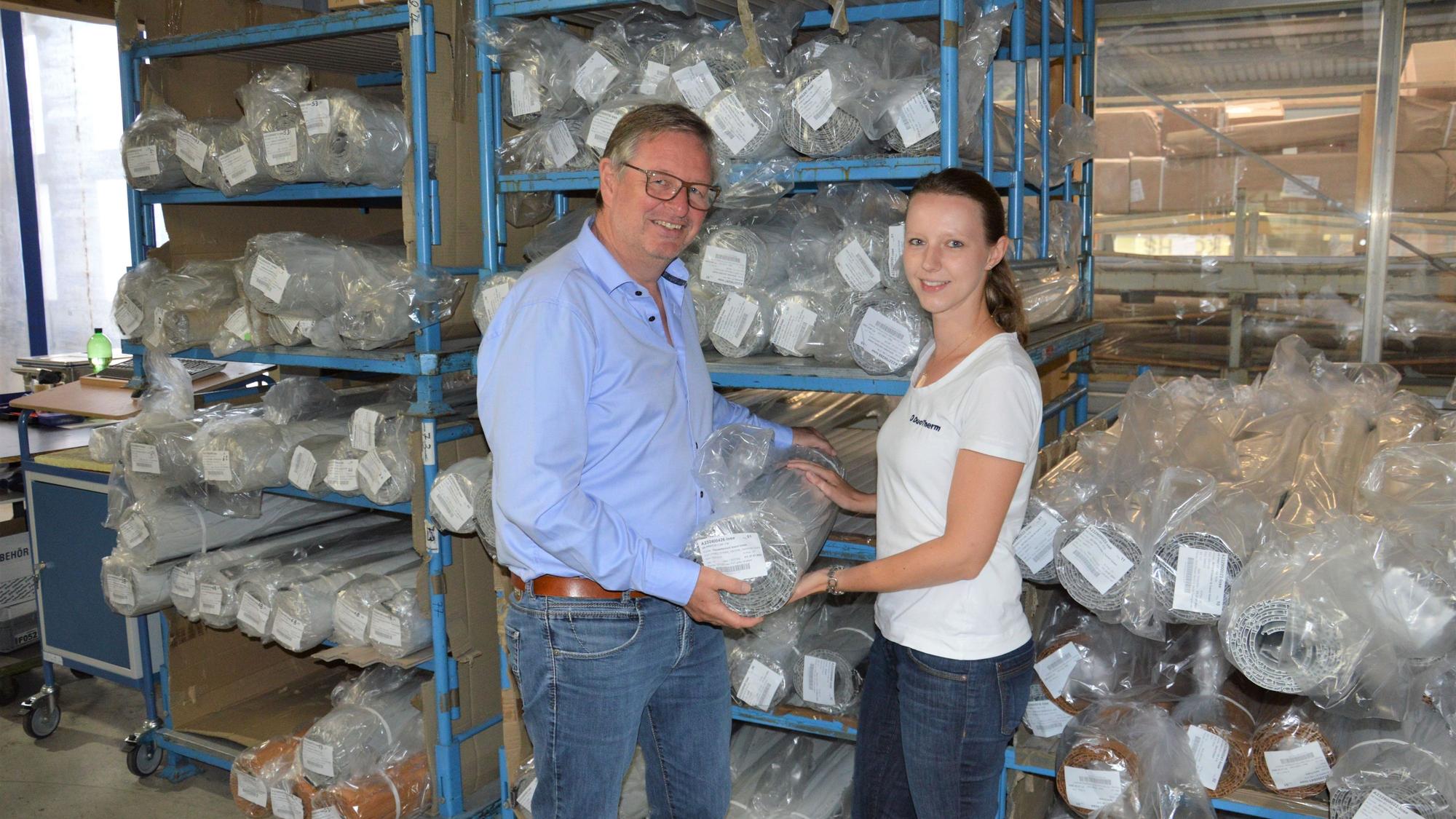 Auf dem Foto halten der Geschäftsführer André Barth und Marketingmitarbeiterin Andrea Rau eine eingepackte Rolllade..