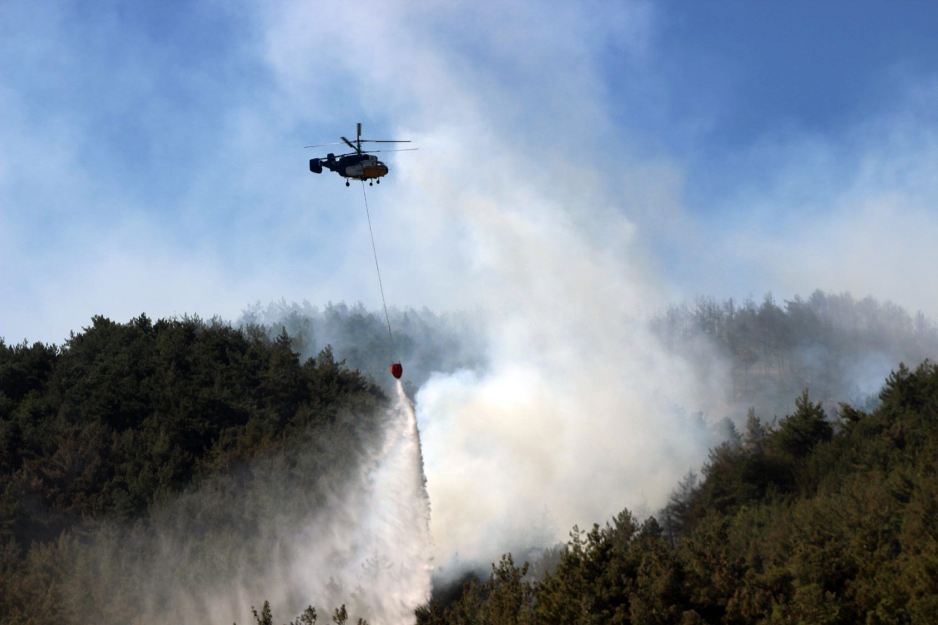 Türkei, Belen: Ein Hubschrauber arbeitet an der Eindämmung eines Waldbrandes.
