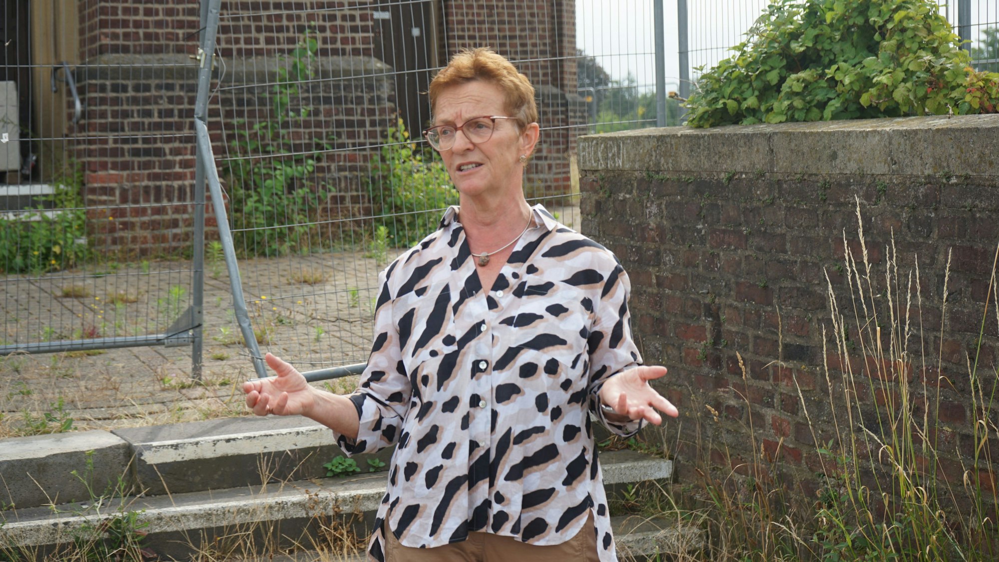Stadtarchivarin Susanne Harke-Schmidt steht vor dem Bauzaun, mit dem die Kirche abgesperrt wurde.
