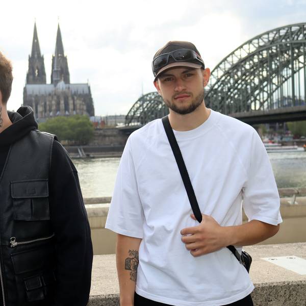 Die Eifeler Musiker Equal (r.) und Liaze posieren am Rhein, im Hintergrund der Kölner Dom.