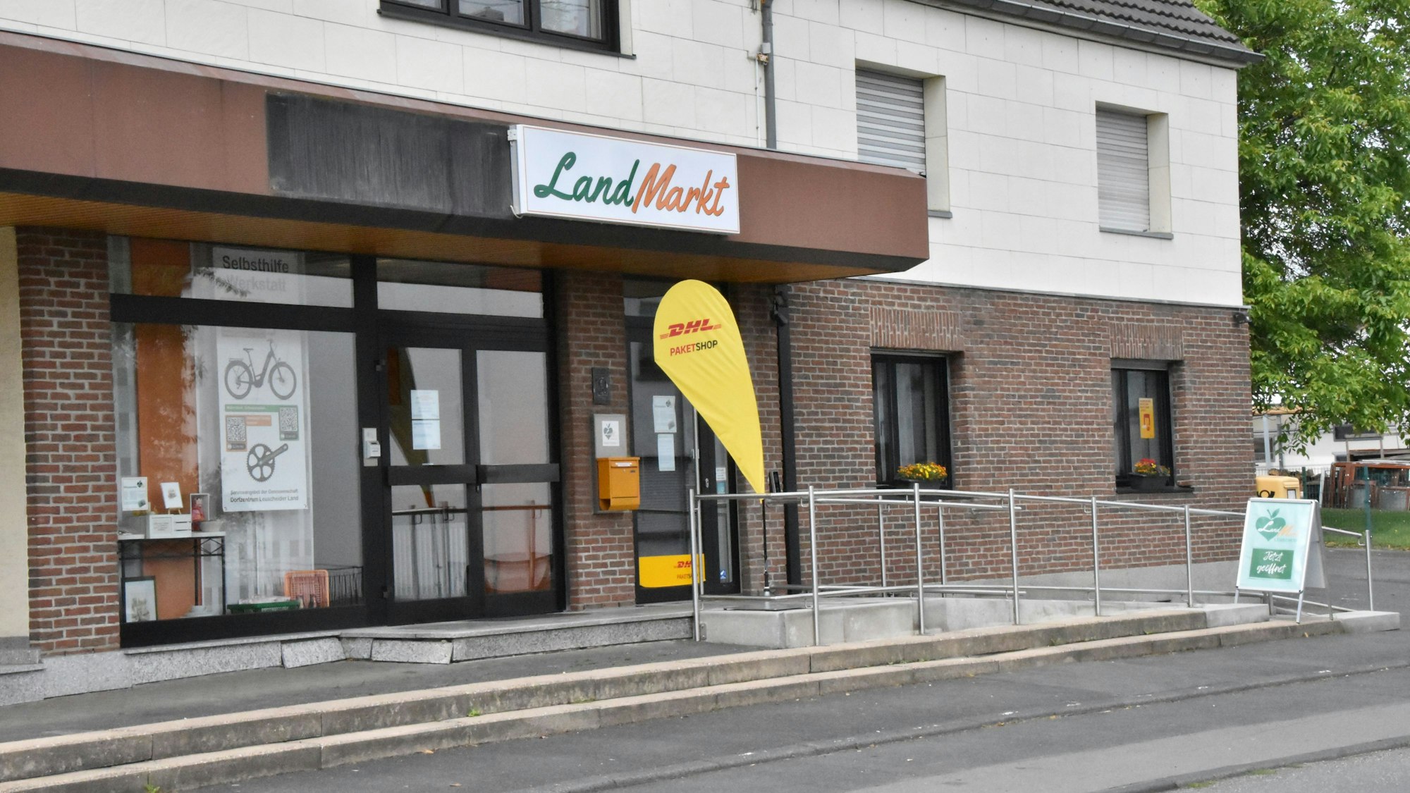 Der Landmarkt an der Saaler Straße im Dorfkern mit Werbeflagge der DHL Deutsche Post.