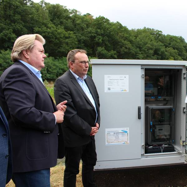 NRW-Umweltminister Oliver Krischer und der Landtagsabgeordnete Klaus Voussem stehen an der neuen Messstation.