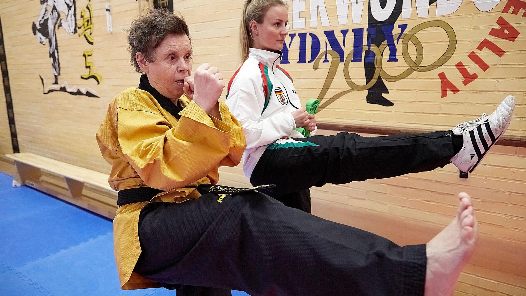 Die fast gehörlose Taekwondo-Sportlerin und ihre Trainerin machen gemeinsam eine Übung.