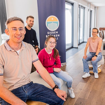 Menschen sitzen in einem zukünftigen Schulraum.