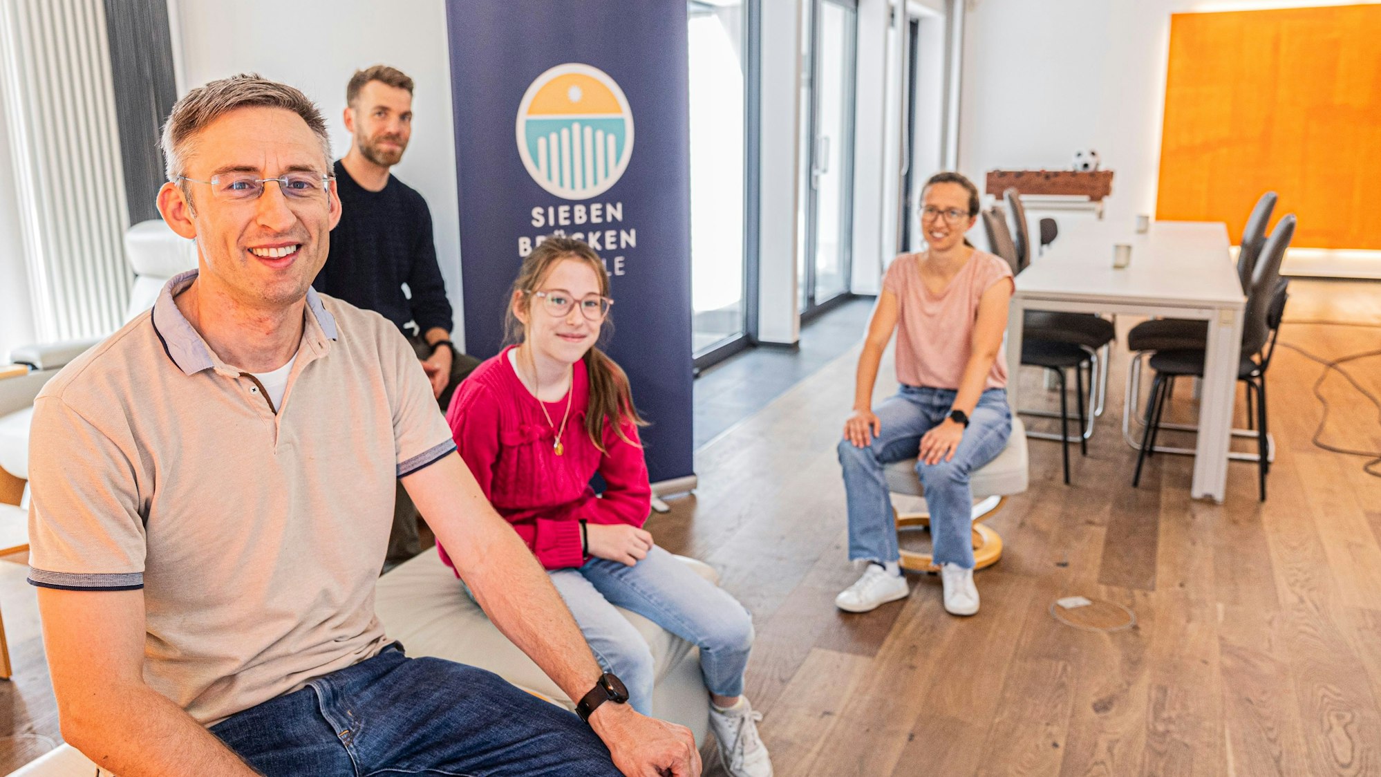 Menschen sitzen in einem neuen Gebäude.