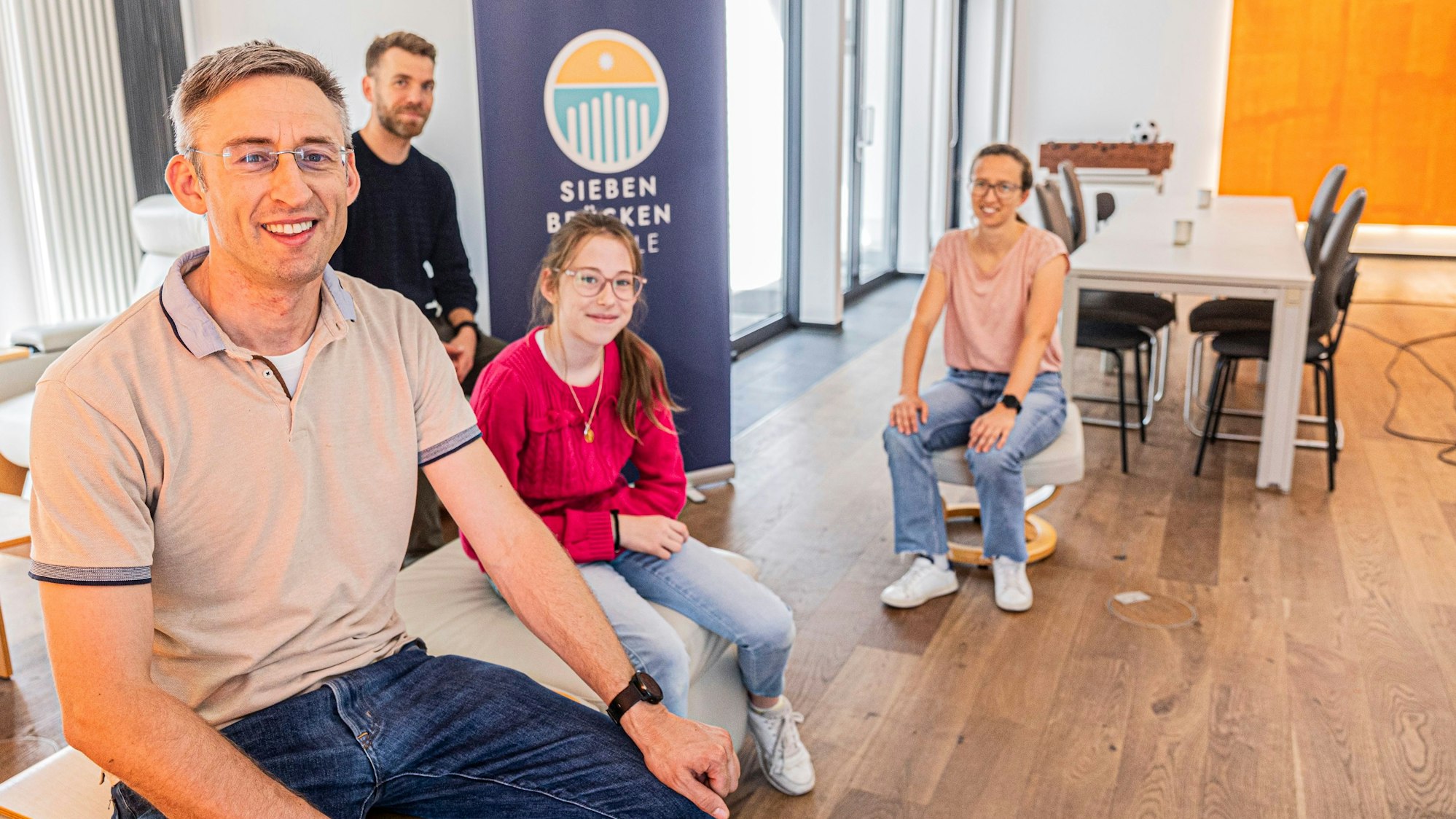 Menschen sitzen in einem zukünftigen Schulraum.