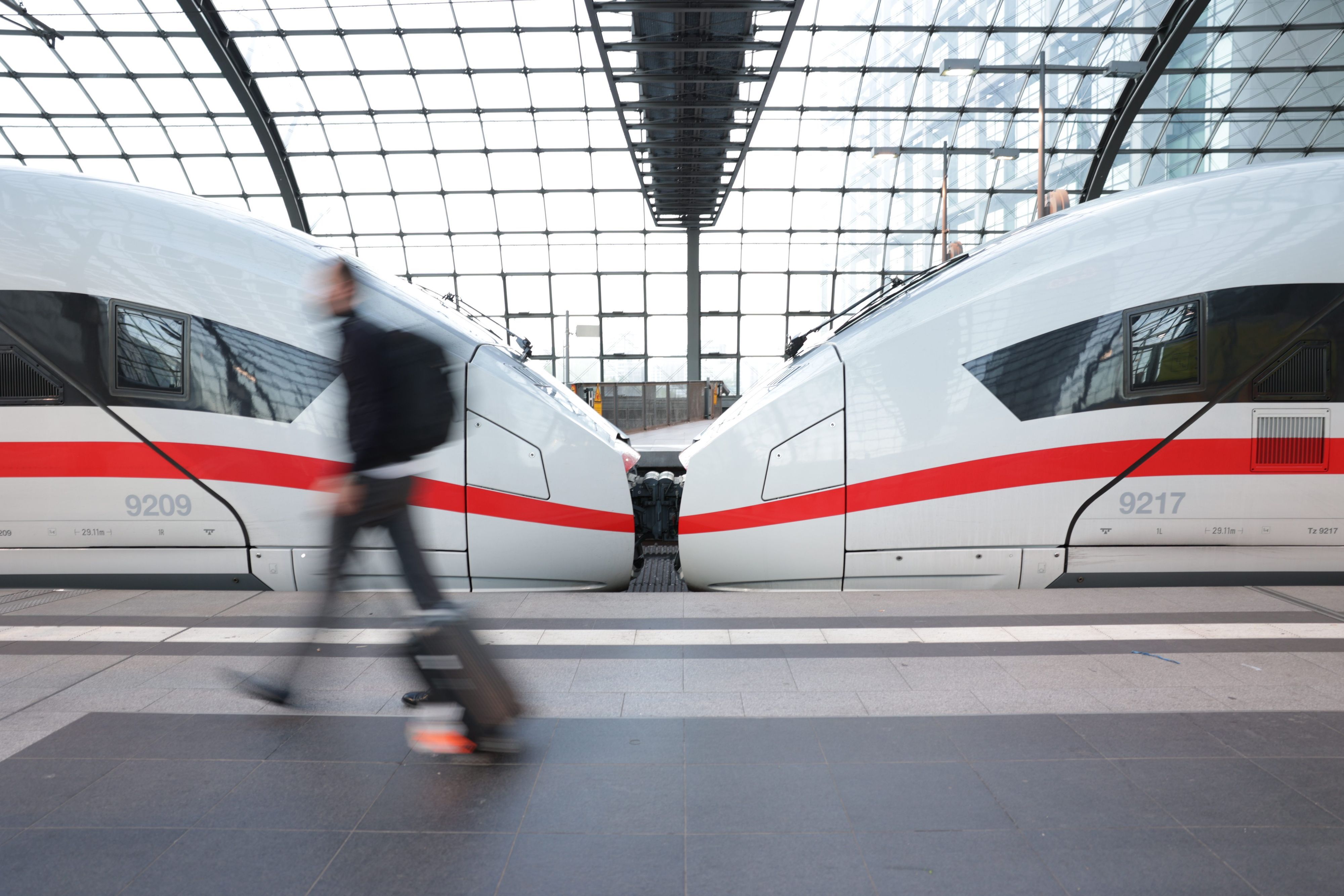 ARCHIV - 11.07.2022, Berlin: Reisende eilen am frühen Morgen zu einem ICE am Hauptbahnhof.