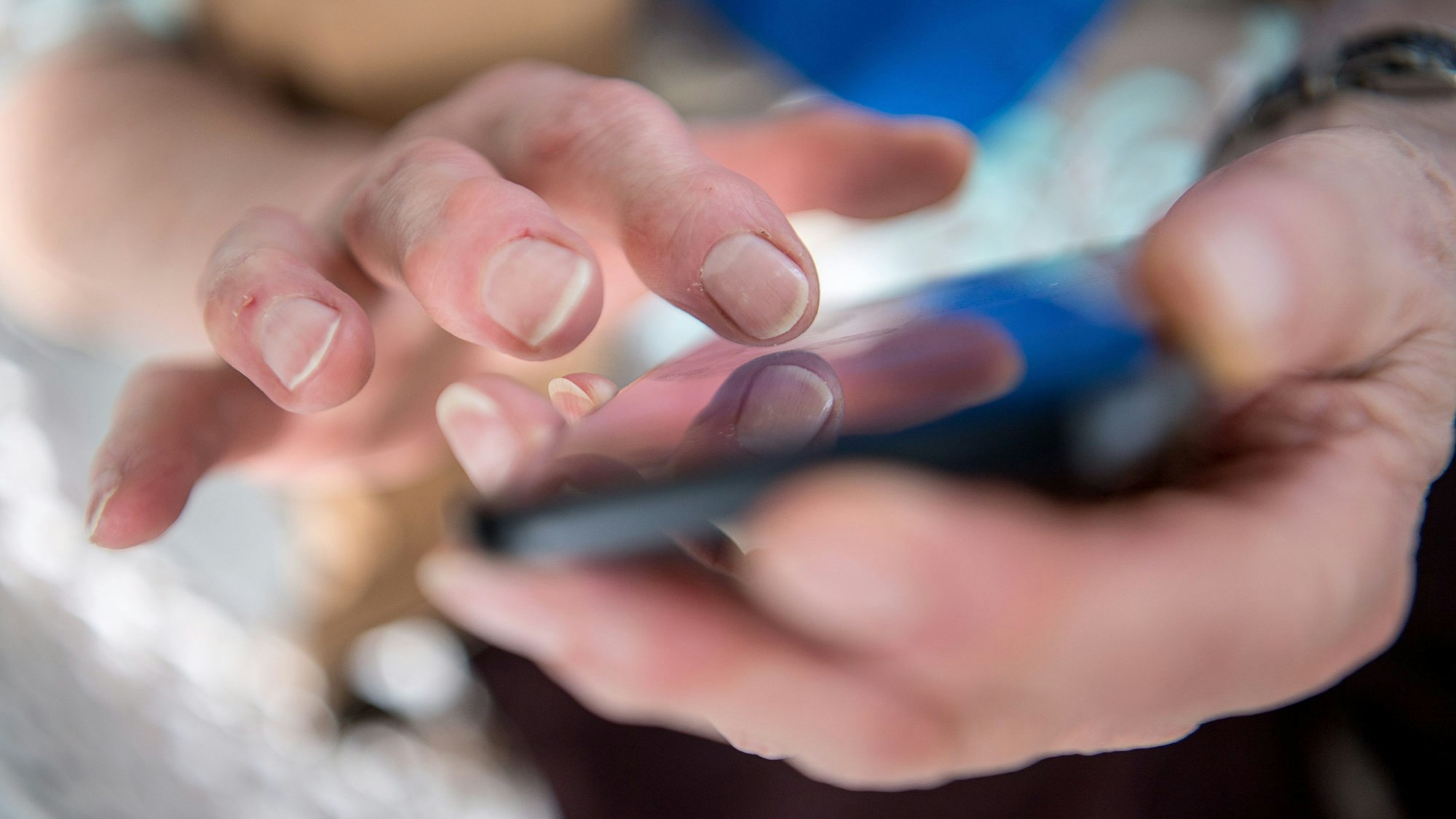 Das Foto zeigt, wie eine Seniorin auf ihrem Smartphone tippt. Die Szene ist gestellt.