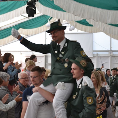 Der neue Schützenkönig wird auf den Schultern durch das Festzelt getragen.