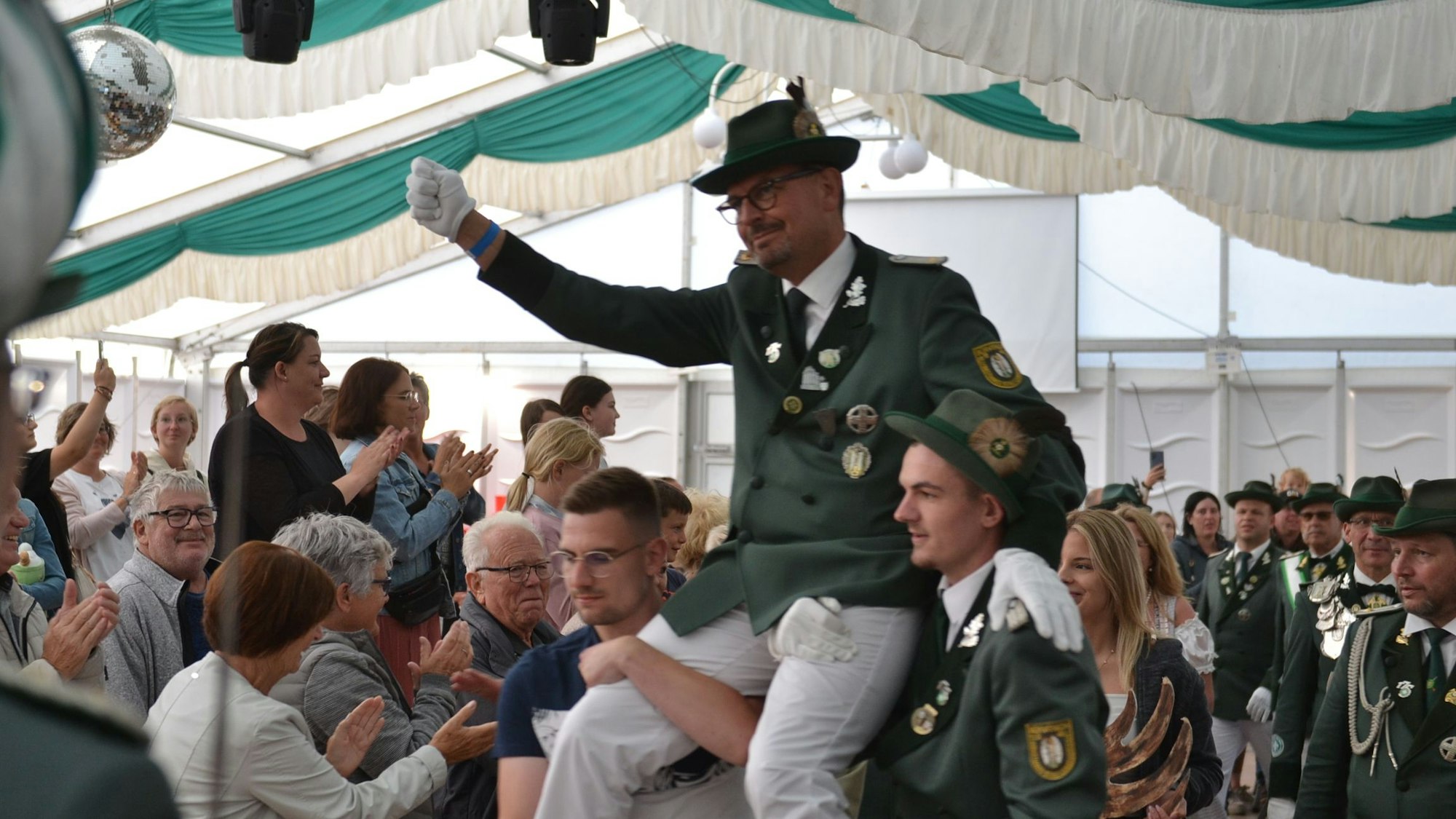 Der neue Schützenkönig wird auf den Schultern durch das Festzelt getragen.