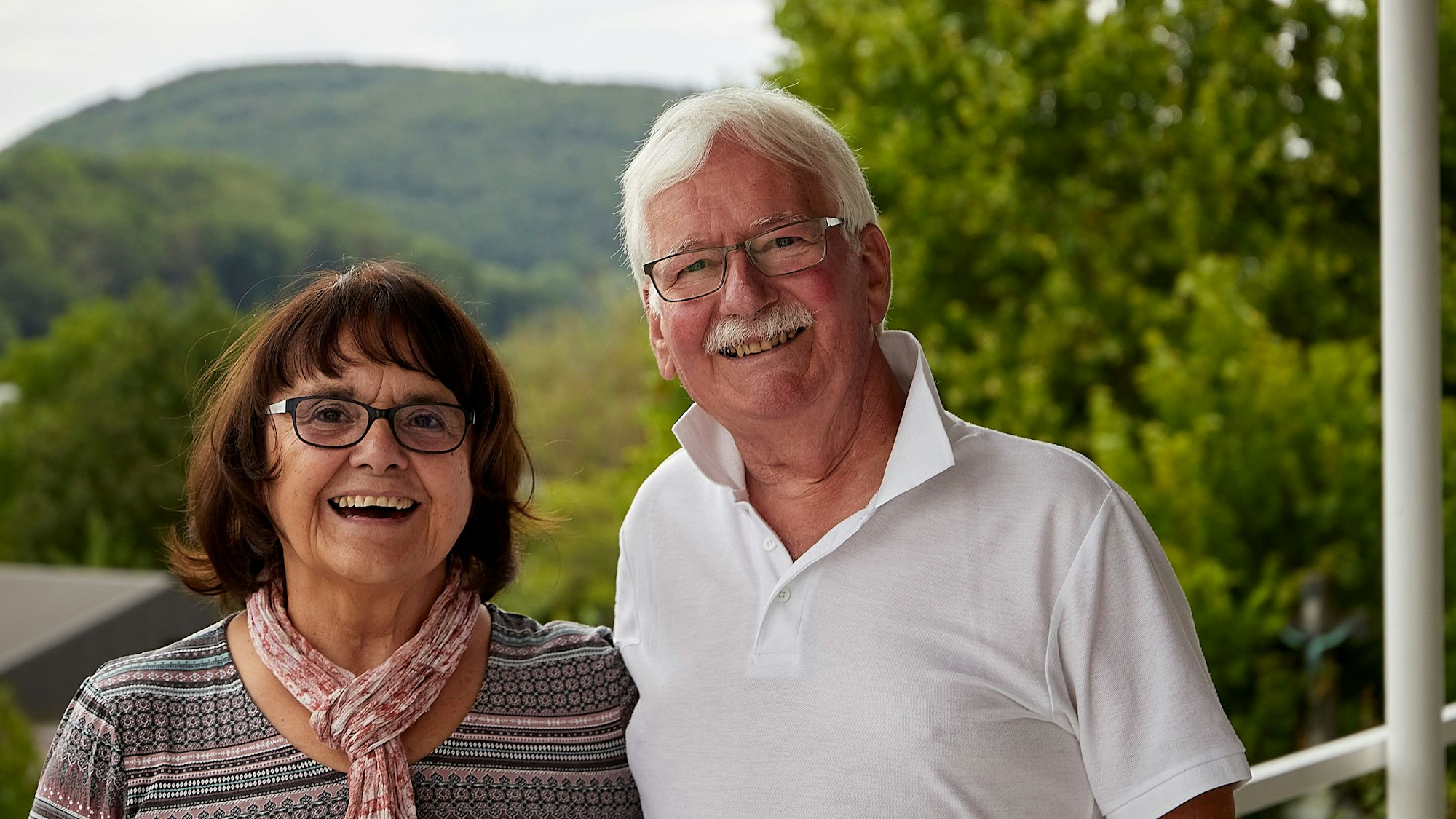 Das Bild zeigt ein Ehepaar im Grünen.