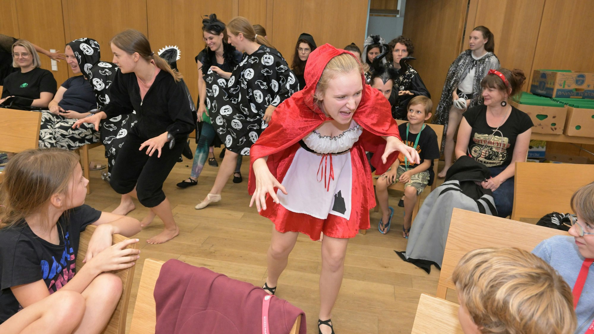 Die Tänzerinnen und Tänzer stürmen verkleidet in den Proberaum und erschrecken die Zuschauenden.