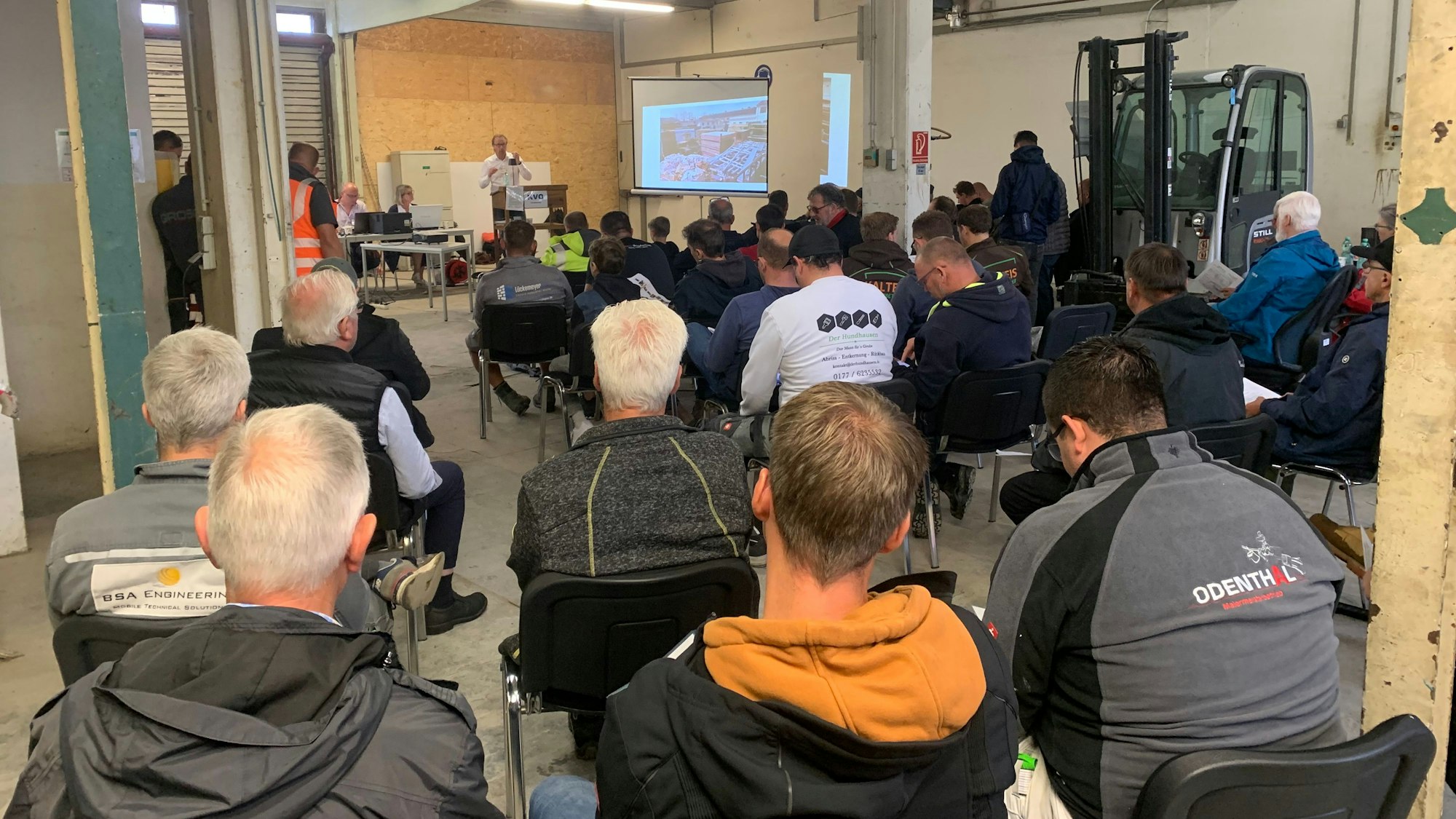 Blick in die Versteigerungshalle in Troisdorf mit Auktionator Markus Schmitz am Versteigerungspult.