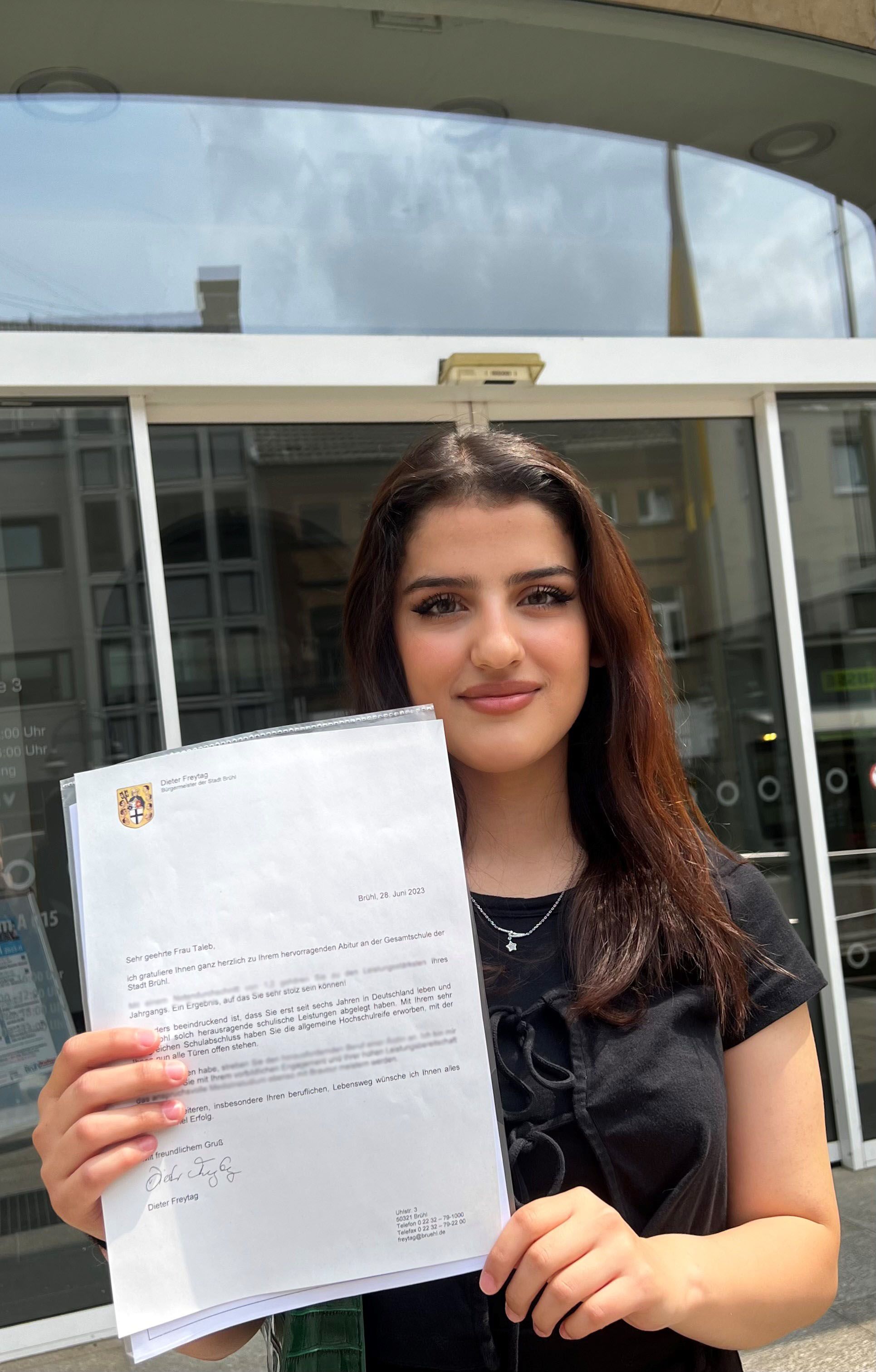 Das Foto zeigt die vor sieben Jahren aus Syrien nach Deutschland geflüchtete Sara Taleb. Sie hält ihr Abiturzeugnis hoch.