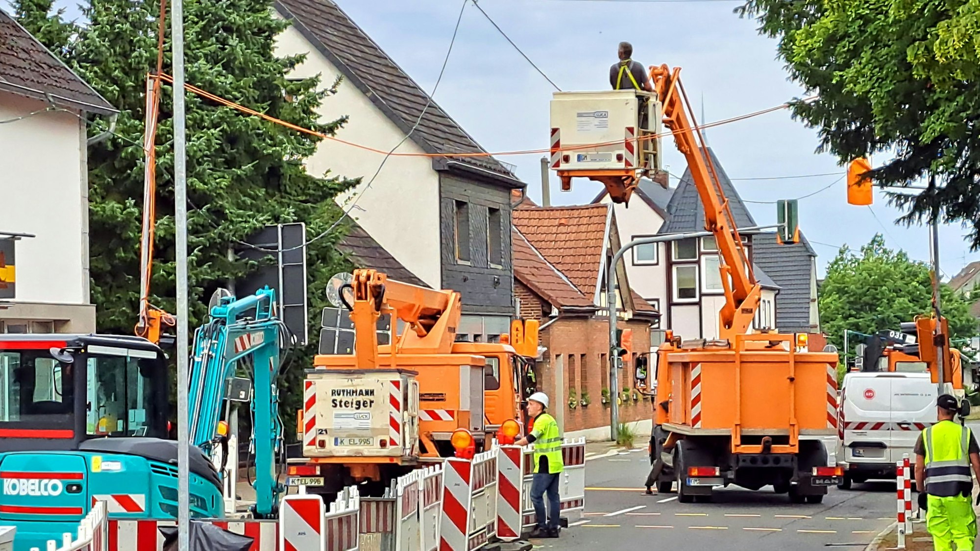 Handwerker arbeiten mit Maschinen an der Straßenbeleuchtung.