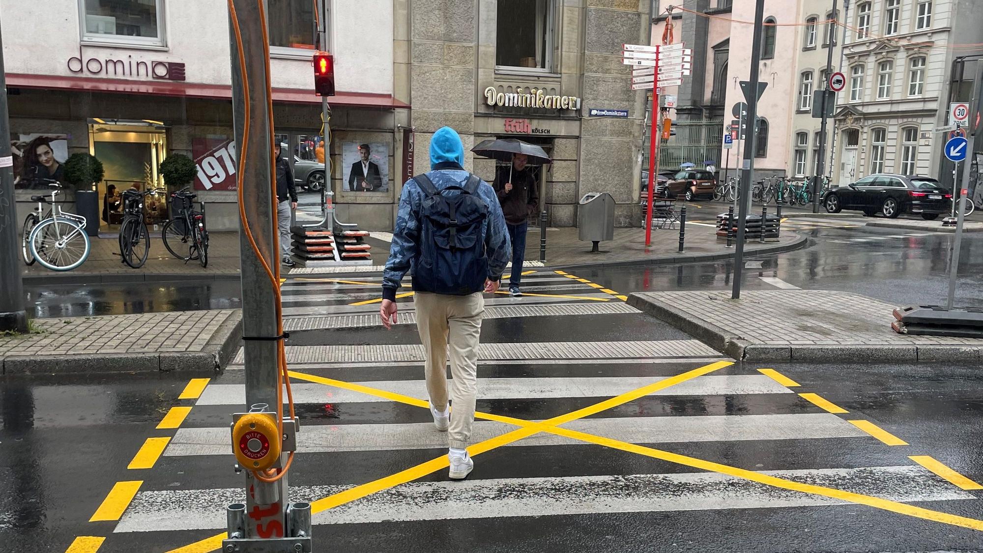 Ein Mann geht über eine rote Baustellenampel an der Baustelle am Kreisverkehr an der Marzellenstraße/An den Dominikanern