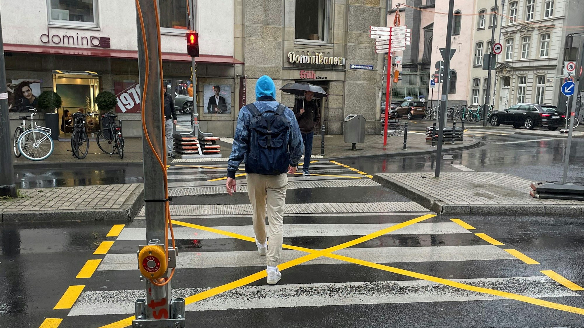Ein Mann geht über eine rote Baustellenampel an der Baustelle am Kreisverkehr an der Marzellenstraße/An den Dominikanern