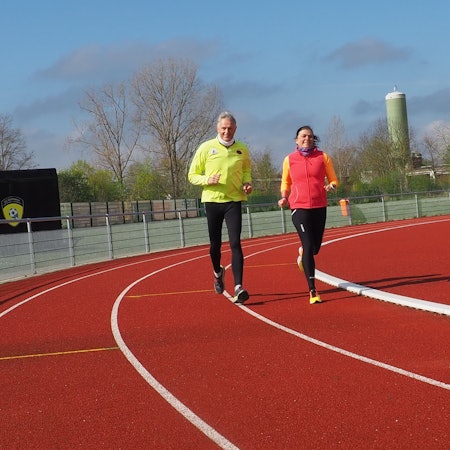 Ein Mann läuft auf einem Sportplatz.
