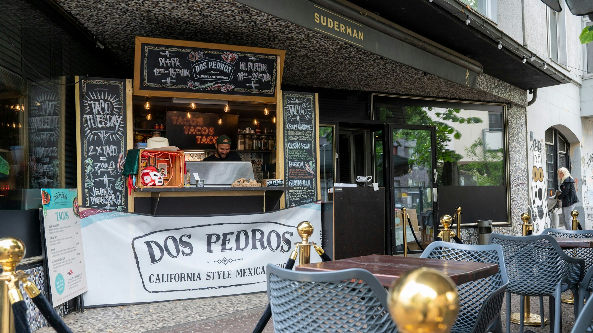 Tische und Stühle vor einem Taco-Stand