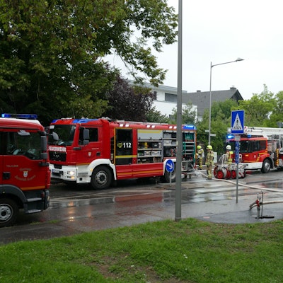 Zahlreiche Einsatzwagen der Feuerwehr stehen auf einer Straße.