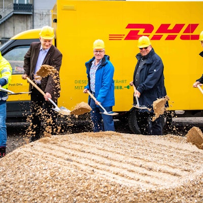 Das Foto zeigt fünf Männer mit Spaten vor einem DHL-Fahrzeug.