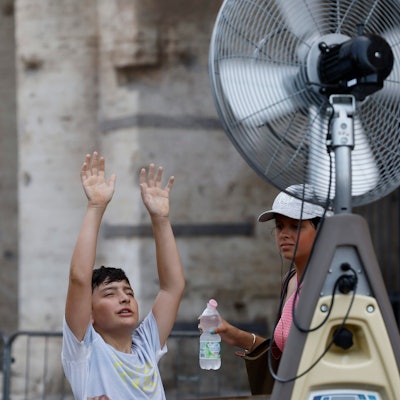 19.07.2023, Italien, Rom: Ein Junge kühlt sich vor einem Ventilator in der Nähe des Kolosseums ab. Die Temperaturen in weiten Teilen Südeuropas liegen weiterhin bei über 40 Grad Celsius. Foto: Cecilia Fabiano/LaPresse/AP/dpa +++ dpa-Bildfunk +++