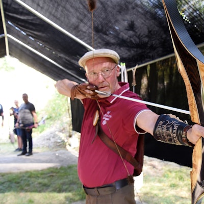 Der Bogenschütze Michael Thielen mit einem gespannten Bogen und Pfeil.