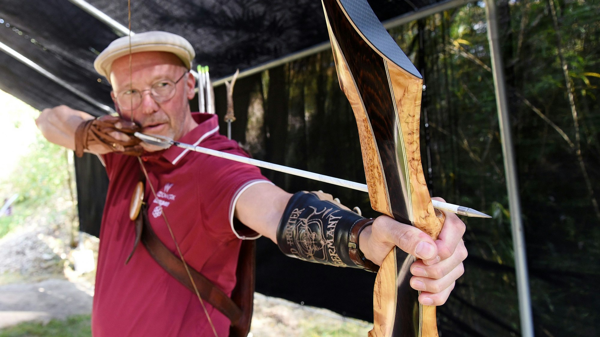 Der Bogenschütze Michael Thielen mit einem gespannten Bogen und Pfeil.
