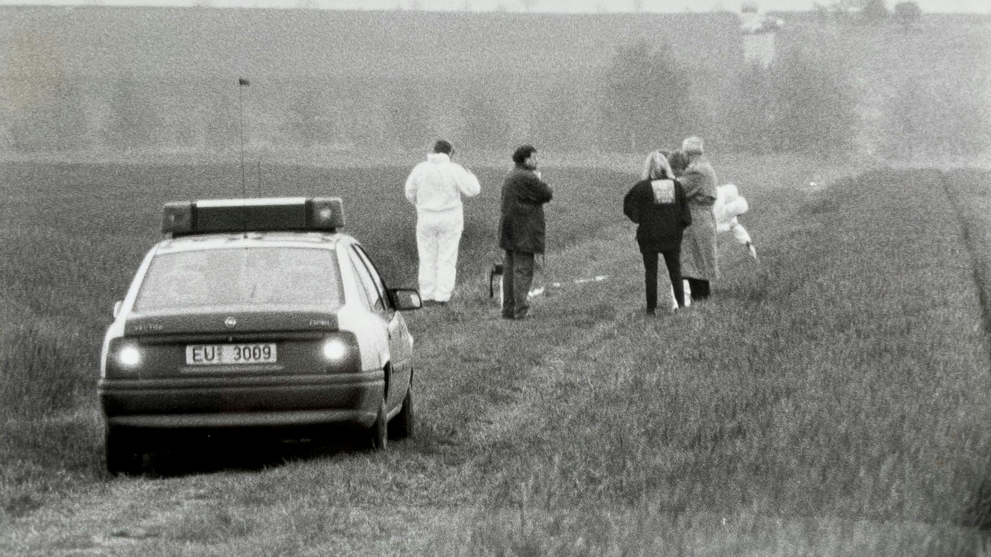 Das Archivbild von 1996 zeigt ein Polizei-Fahrzeug auf einem Feldweg und einige Menschen.
