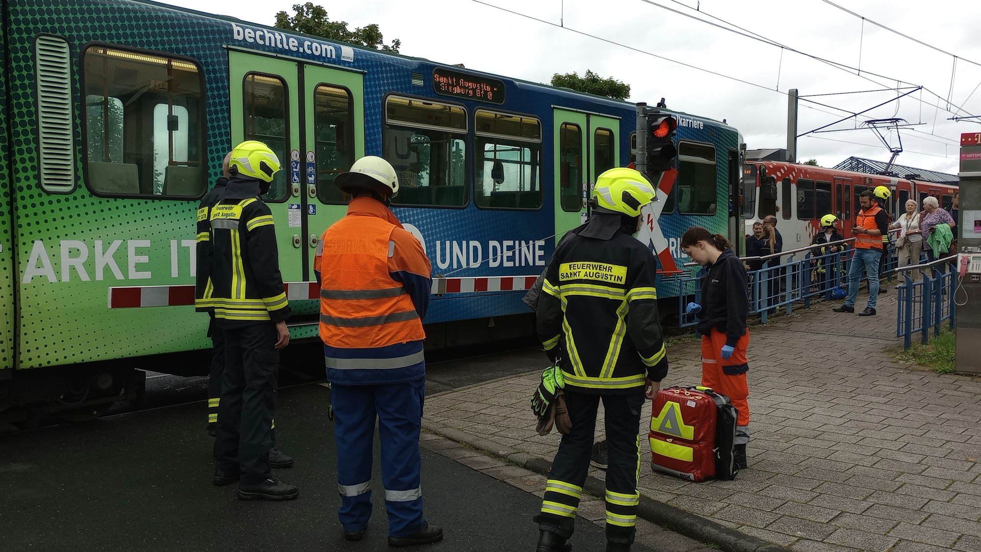 Rettungskräfte und Feuerwehr stehen an einer Stadtbahn.