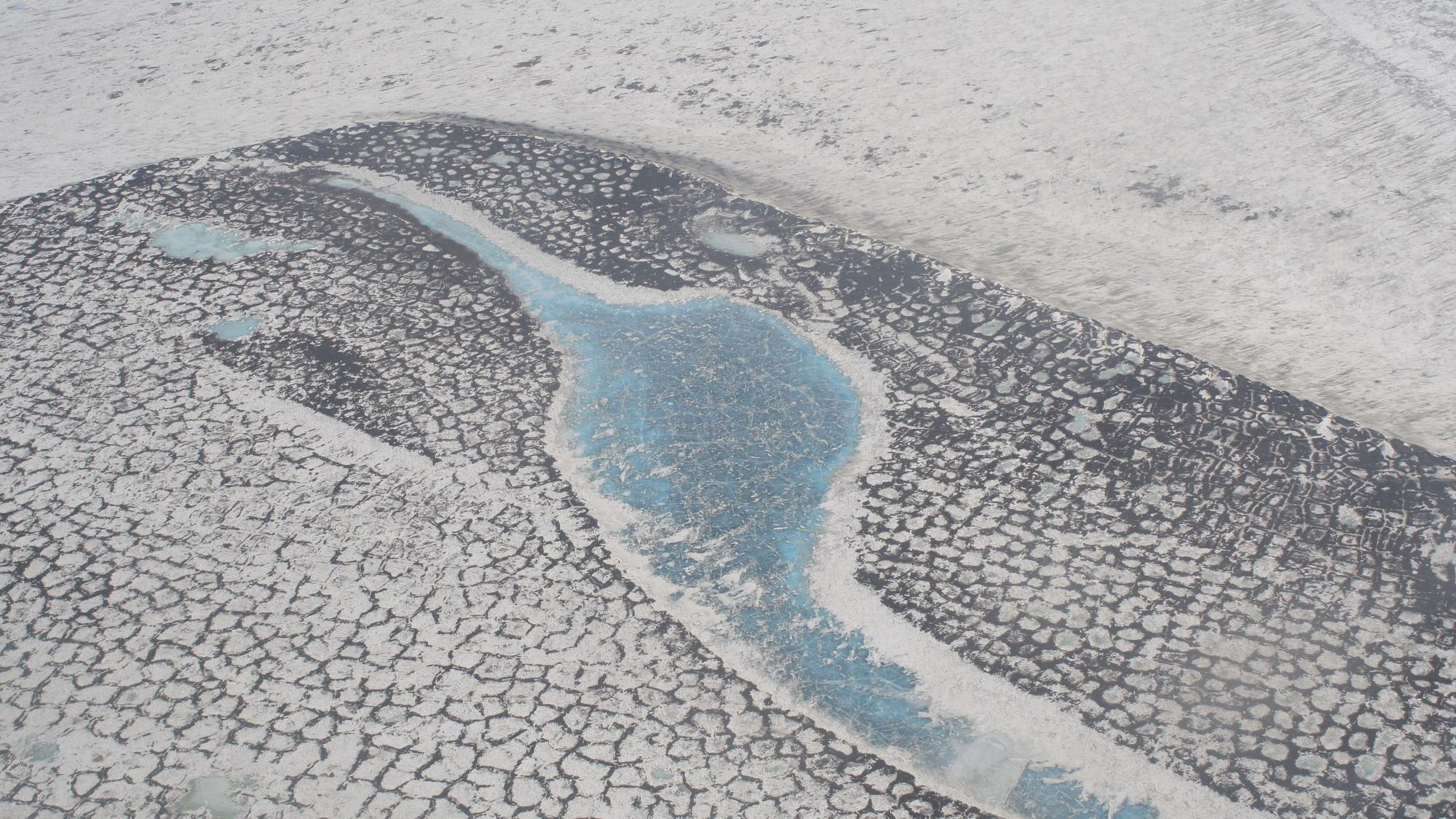Luftaufnahme der russischen Tundra im Lena-Delta, das das typische Muster der Permafrostgebiete zeigt. Wenn die Temperaturen steigen, dann bekommen die Menschen in Russland die Folgen mitunter drastisch zu spüren. Straßen sacken ab. Häuser können einstürzen. +