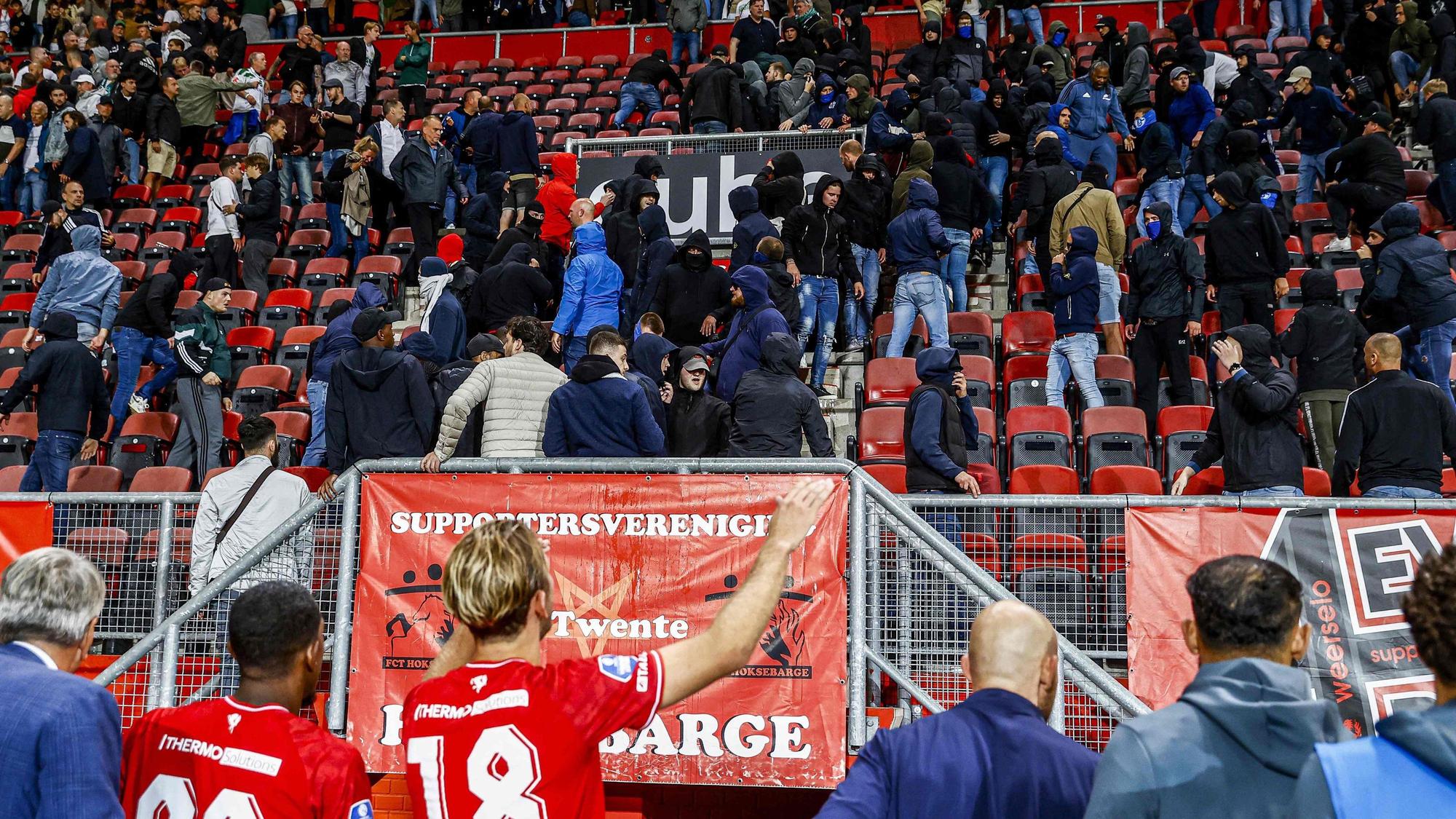 Unruhen auf der Tribüne mit Fußballspielern im Vordergrund