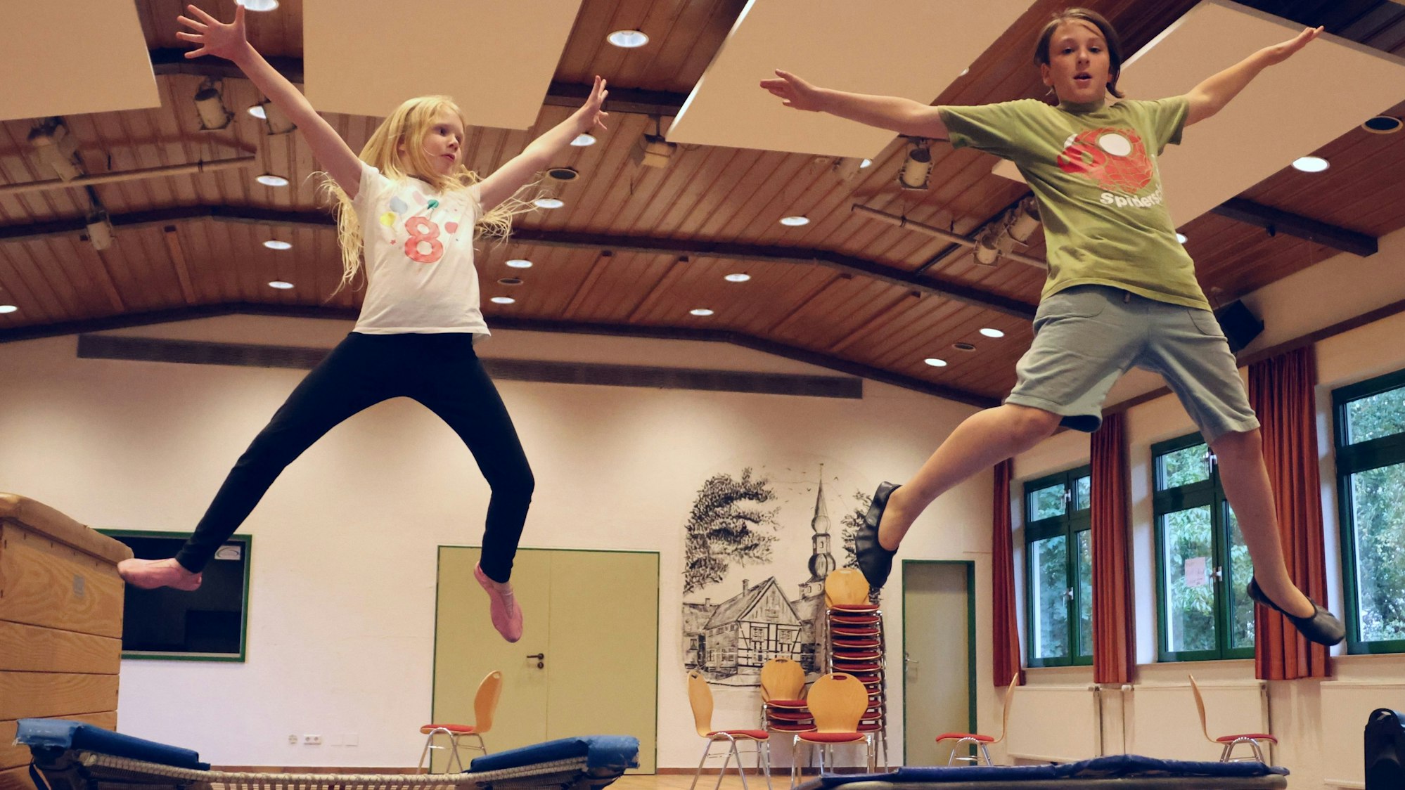 Ein Mädchen und ein Junge springen Trampolin.