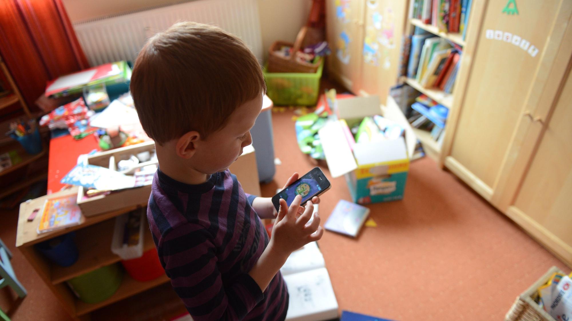 ARCHIV - 09.04.2012, Berlin: ARCHIV - ILLUSTRATION - Ein Junge spielt in seinem Kinderzimmer auf einem Smartphone ein Computerspiel, aufgenommen am 10.04.2012 in Berlin. Viele Kinder spielen gerne Spiele auf Smartphones.
Für dein ganz persönliches Hörbuch drückst du den Aufnahmeknopf beim Handy. Dann kannst du von einem gemeinsamen Erlebnis erzählen oder eine Geschichte vorlesen. (zu dpa: «Geschenke in letzter Minute») Foto: Jens Kalaene/dpa - Honorarfrei nur für Bezieher des Dienstes dpa-Nachrichten für Kinder +++ dpa-Nachrichten für Kinder +++