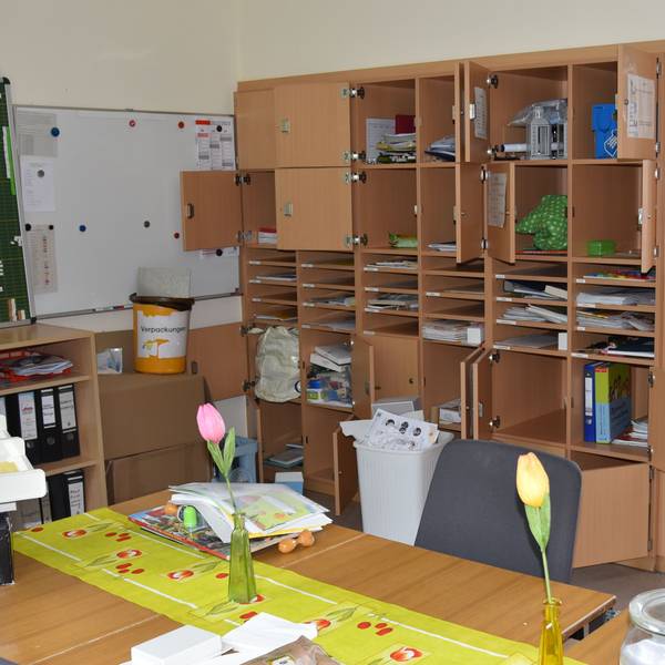In einem Lehrerzimmer sind mehrere Lehrerfächer aufgebrochen, der Inhalt liegt auf dem Boden verstreut.