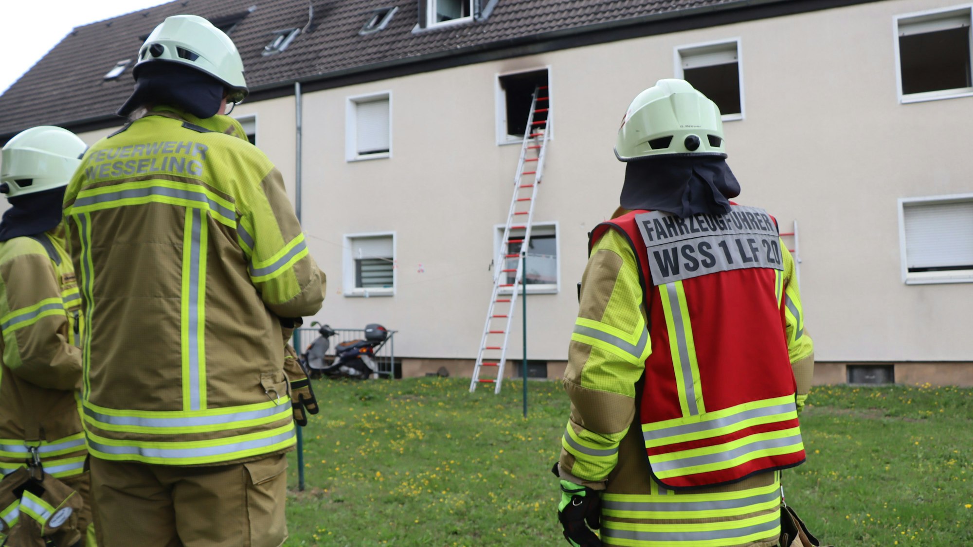 Einsatzkräfte der Feuerwehr begutachten den Einsatzort, eine Steckleiter führt zum Brandort.