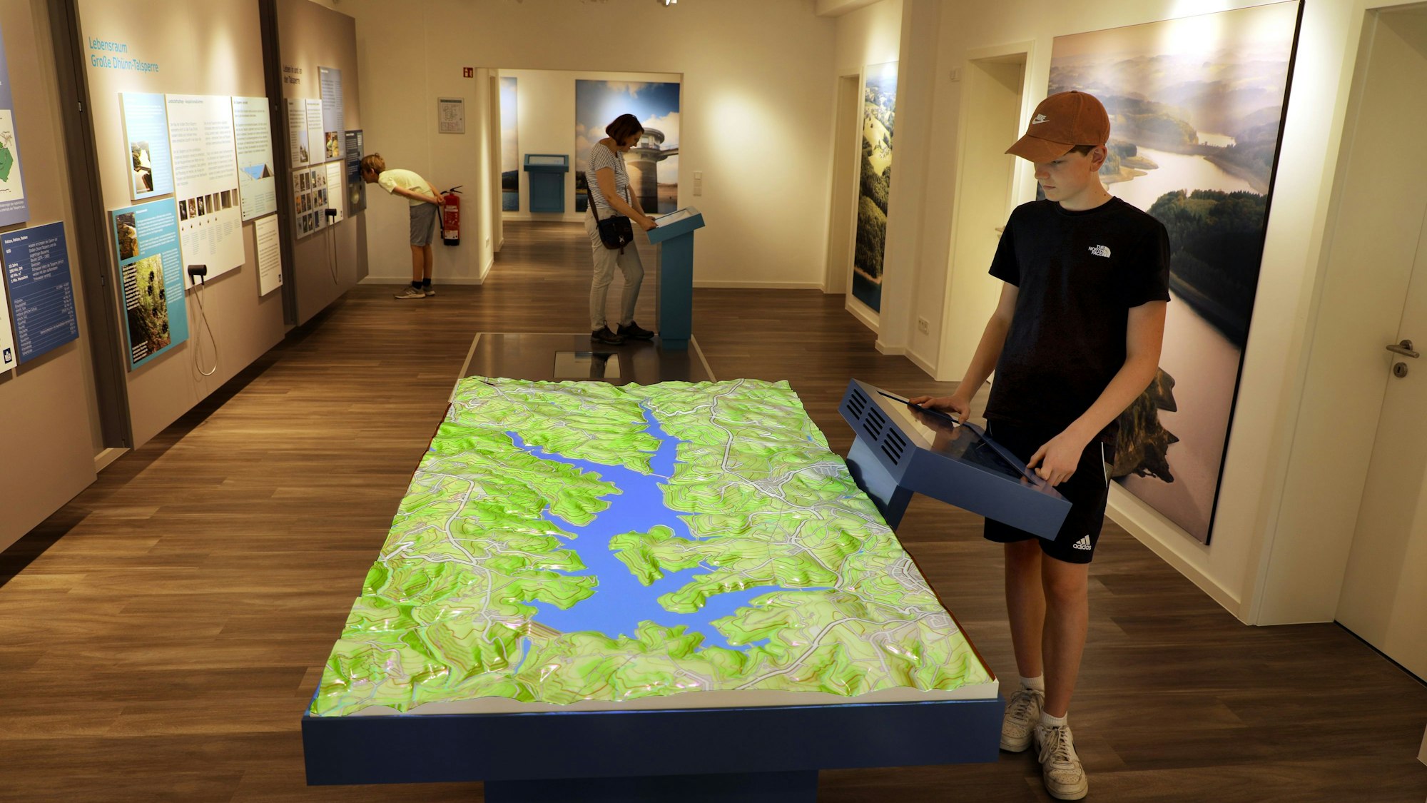 Menschen besichtigen eine Infoausstellung zum Thema Wasser des Vereins Aqualon an der Großen Dhünn-Talsperre.