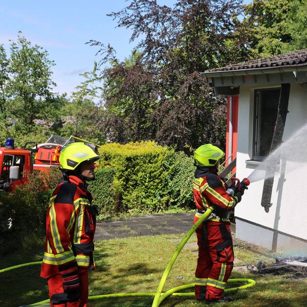 Bild von zwei Feuerwehrleuten, die löschen.