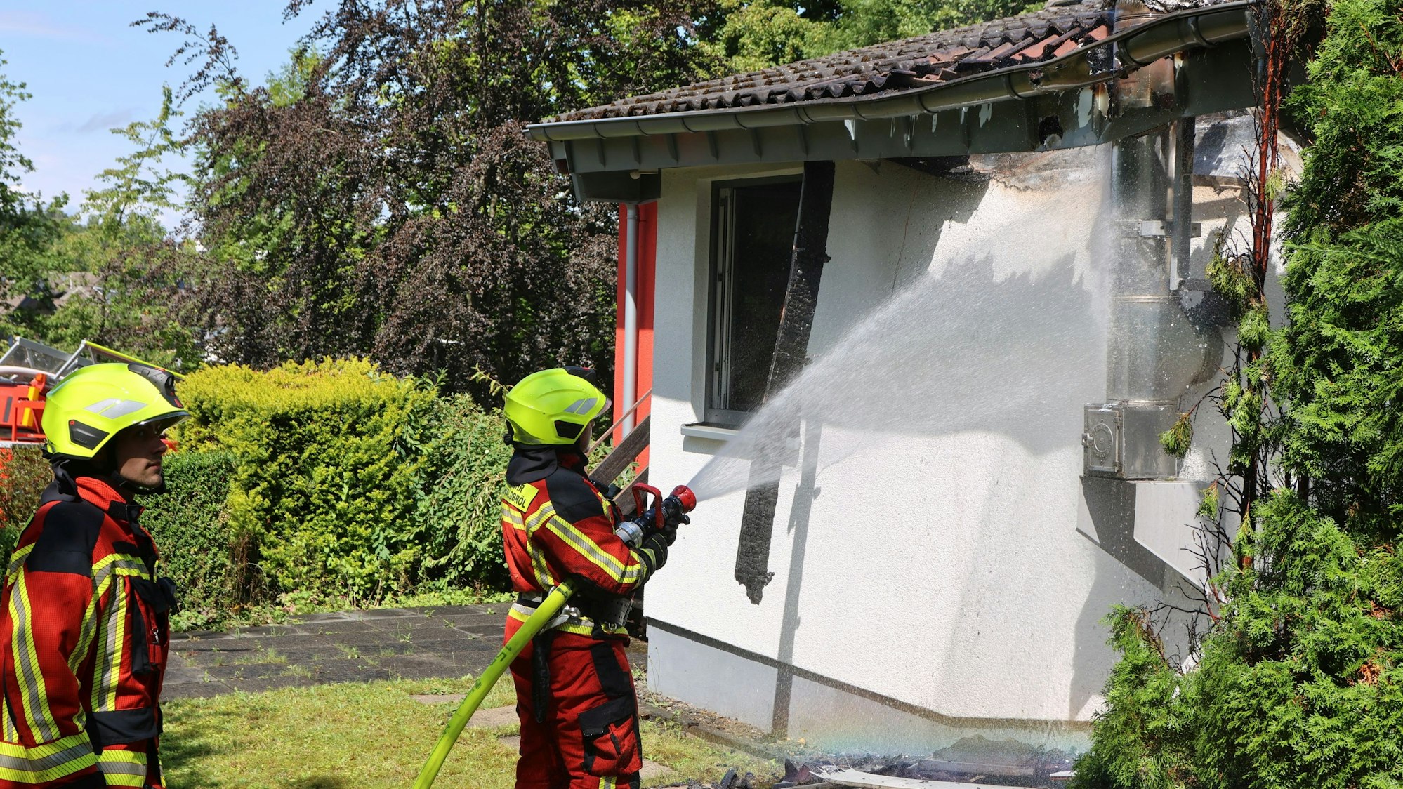 Bild von zwei Feuerwehrleuten, die löschen.