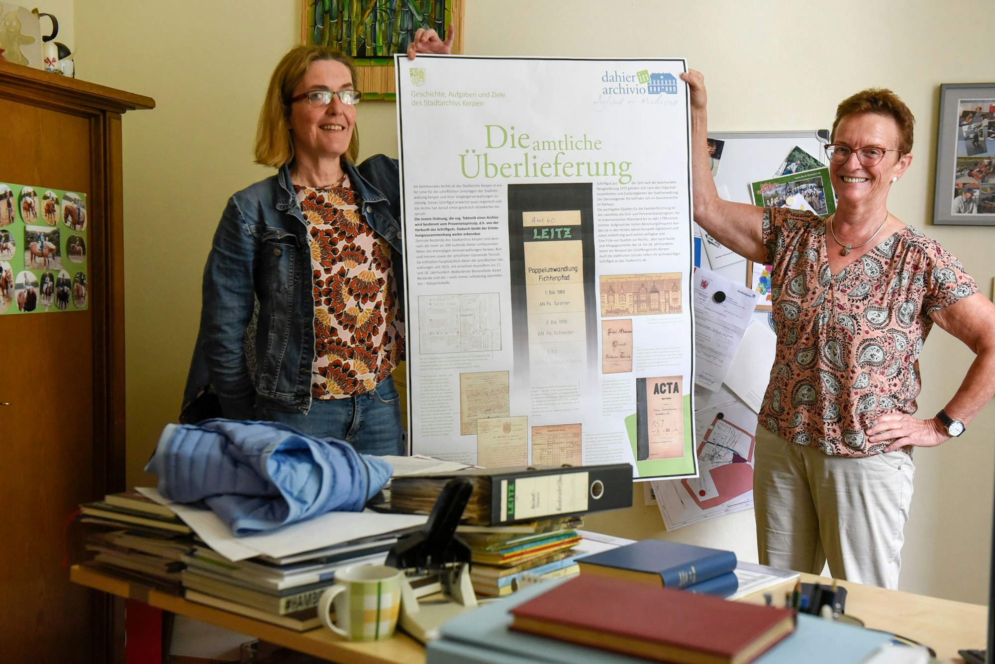 Das Bild zeigt Susanne Kremmer und Susanne Harke-Schmidt, die die ersten Ergebnisse zur Ausstellung zum Thema Archivarbeit zeigen.