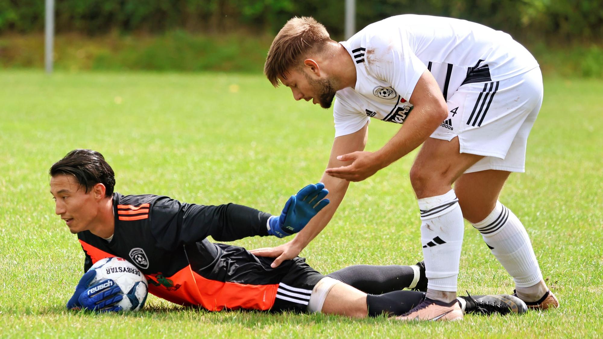 Ein Erftstädter Spieler stützt sich bei Torhüter Aziz Khwaja auf - am Gesäß.