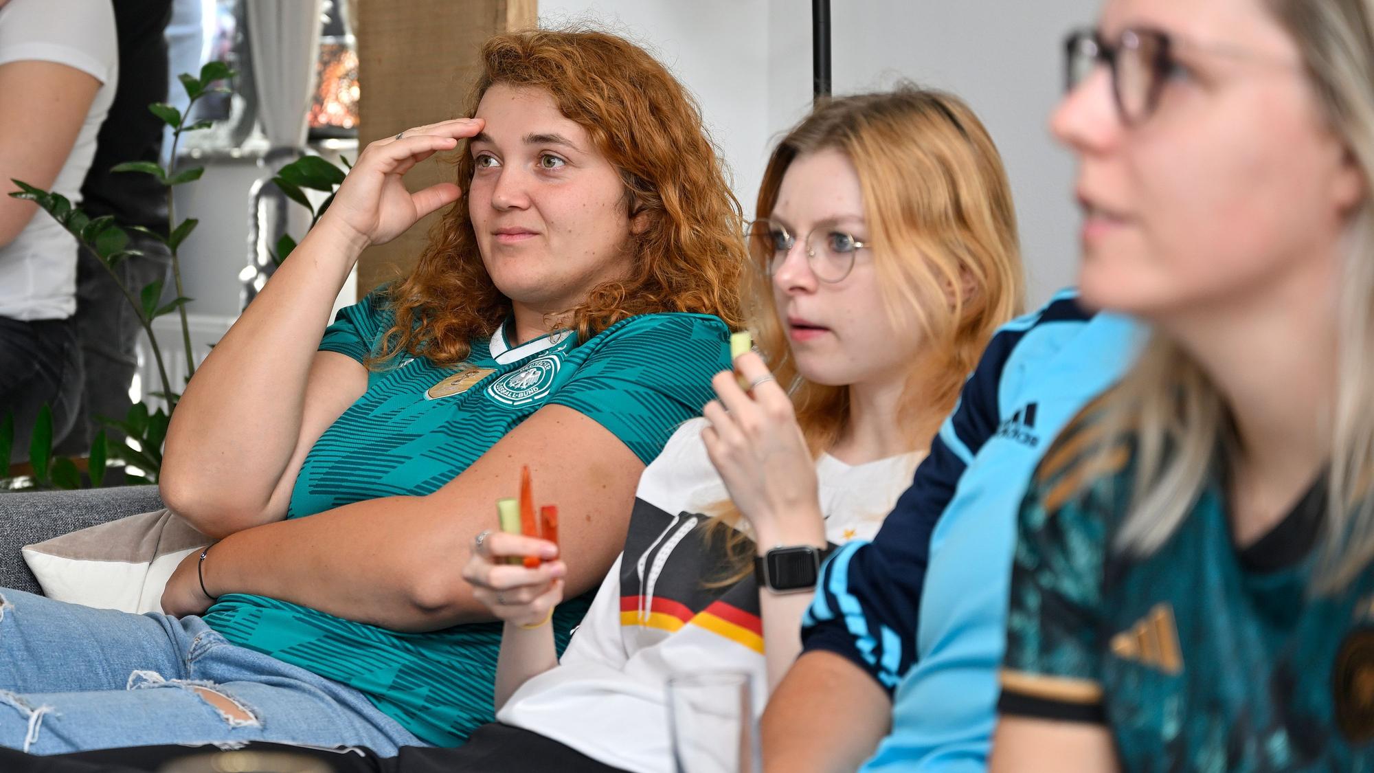 Frauen des schauen auf den Fernseher und schauen enttäuscht.