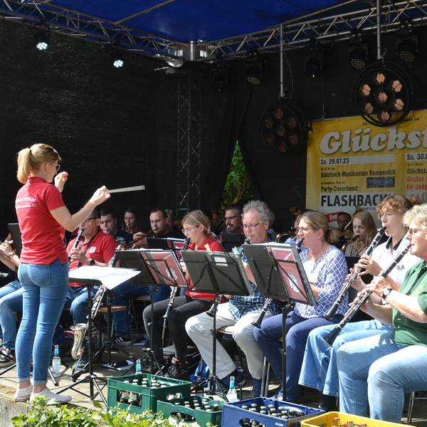 Das Foto zeigt eine Dirigentin vor einem Orchester.