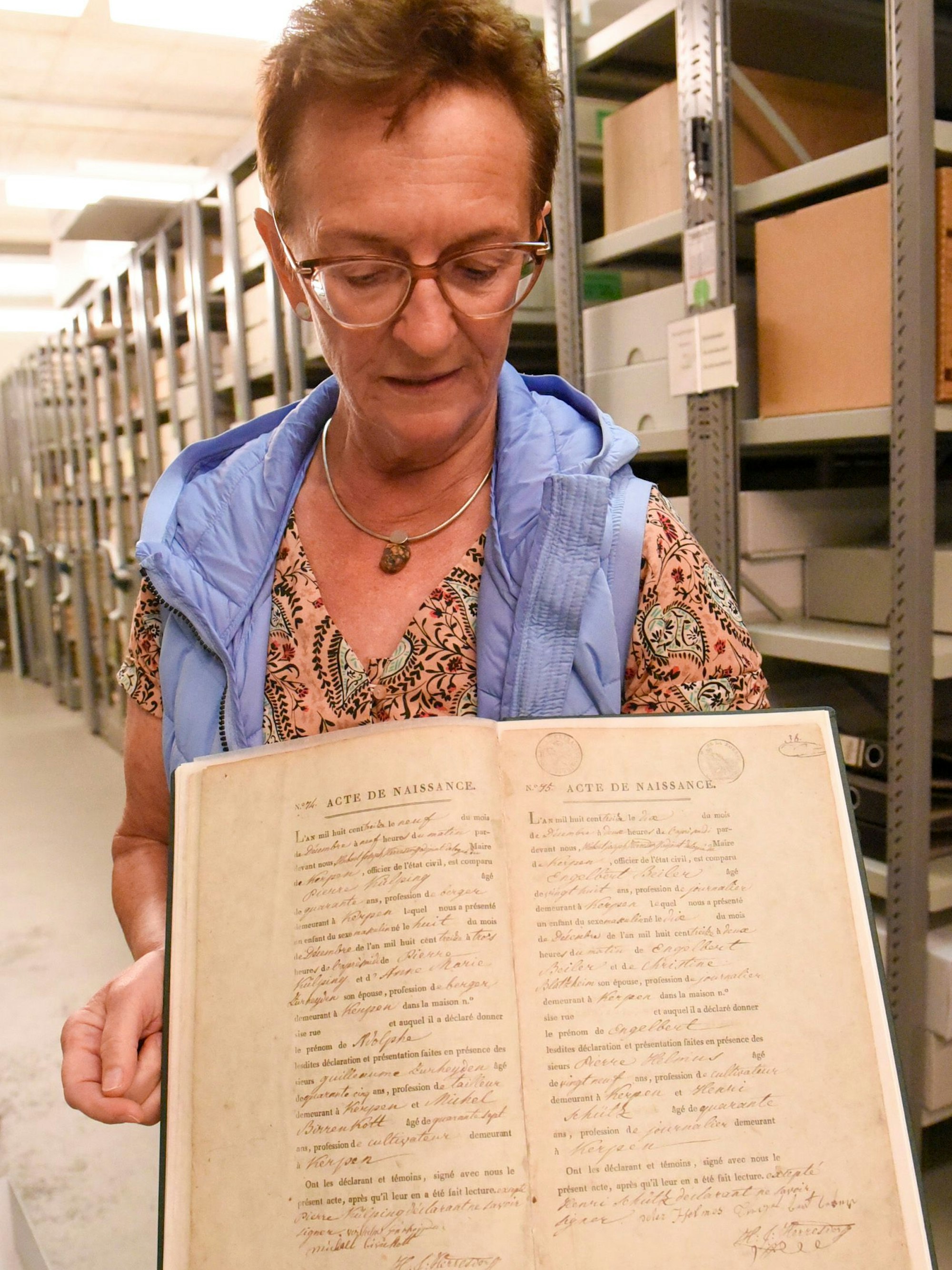 Das Bild zeigt Susanne Harke-Schmidt, die die Geburtsurkunde von Adolph Kolping in den Händen hält.