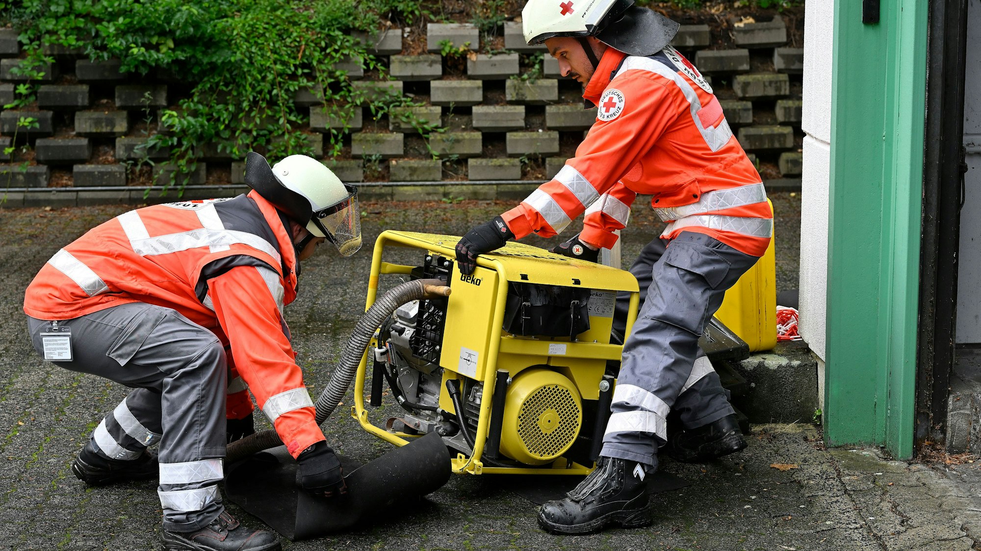 Einsatzkräfte des Deutschen Roten Kreuzes stellen ein Stromaggregat auf.