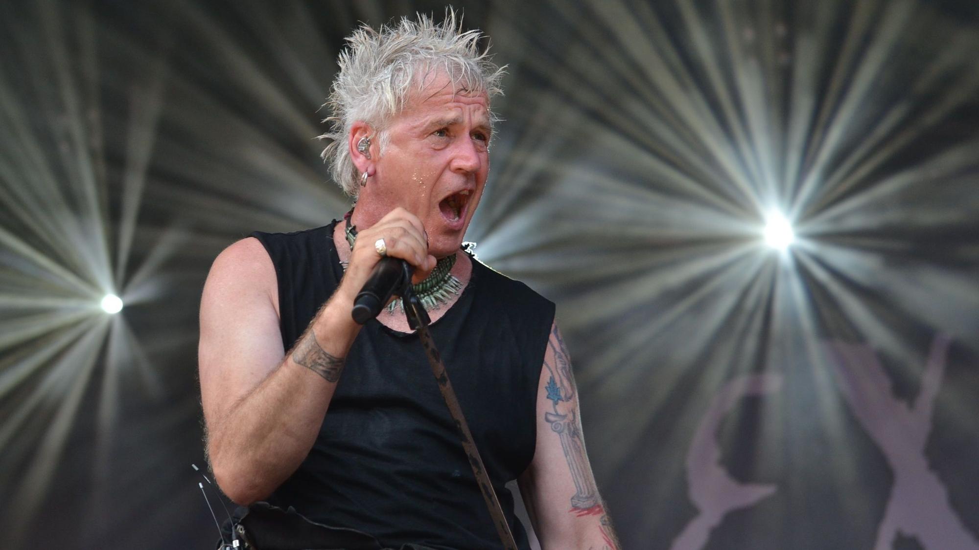 Das Bild zeigt Michael Rhein, den Frontsänger der Band In Extremo, bei einem Konzert.