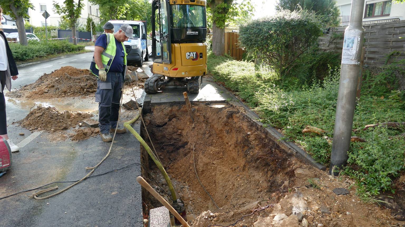 Mitarbeiter der Stadtwerke suchten sofort nach dem Leck in der Hauptwasserleitung. Einer steht vor dem Loch in der Straße.